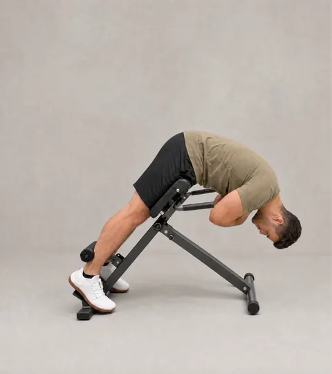 Stage 3: the bottom of a full rep, upper body folded down over the pad with the back rounded.